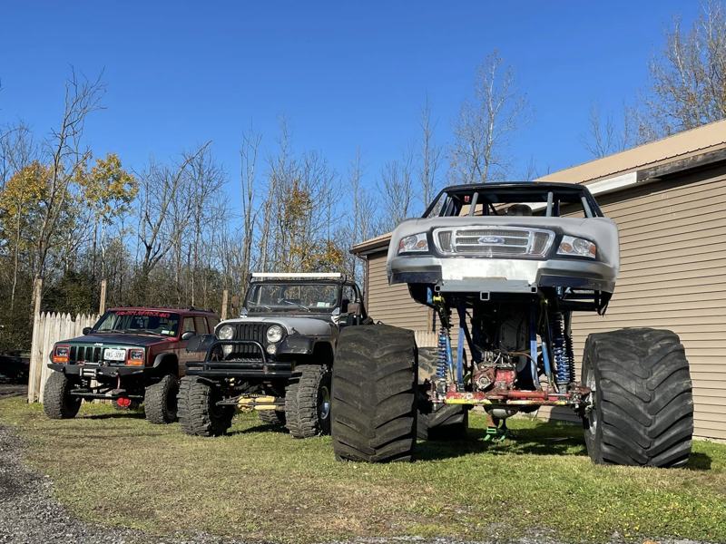Jeeps and a lifted pickup beside the building